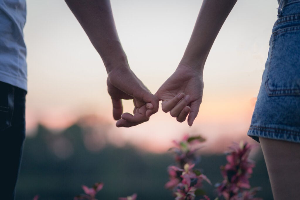 couple holding pinky fingers