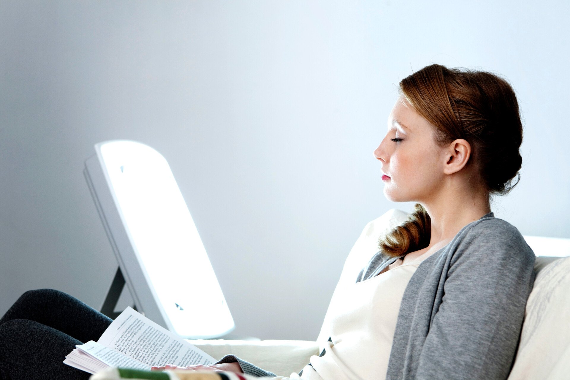 a woman sat in front of a light box - light therapy