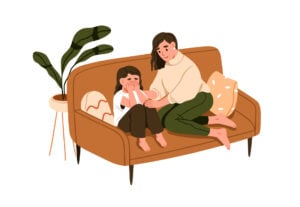 A woman sat on a sofa comforting a sad young girl with hands covering her face