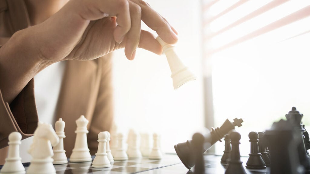 a hand moving chess pieces